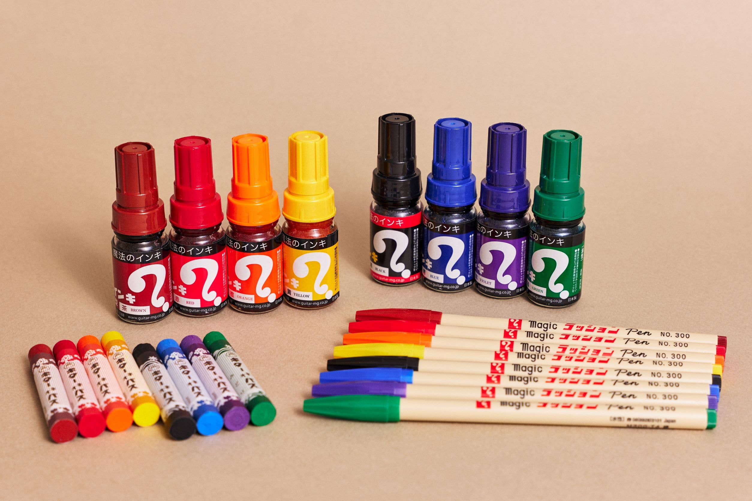 Set of colorful markers and pens on a beige background