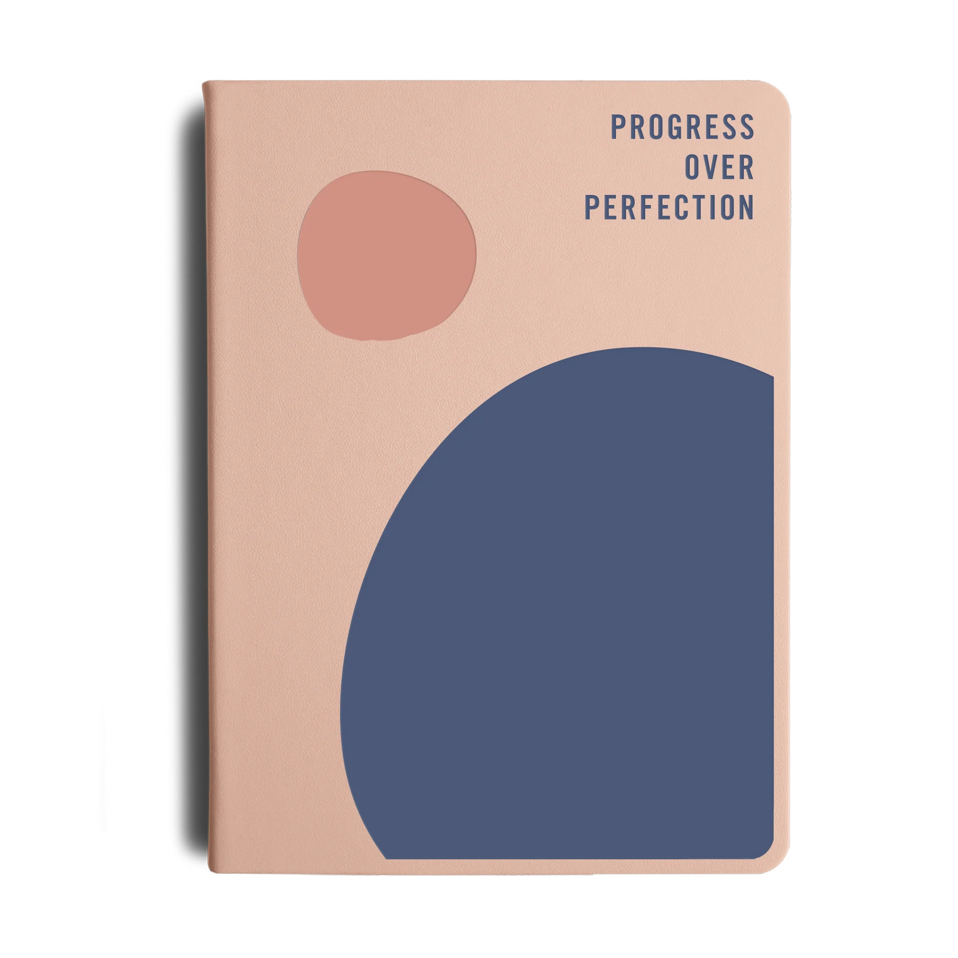 Notebook with abstract shapes and 'Progress Over Perfection' text on a beige background