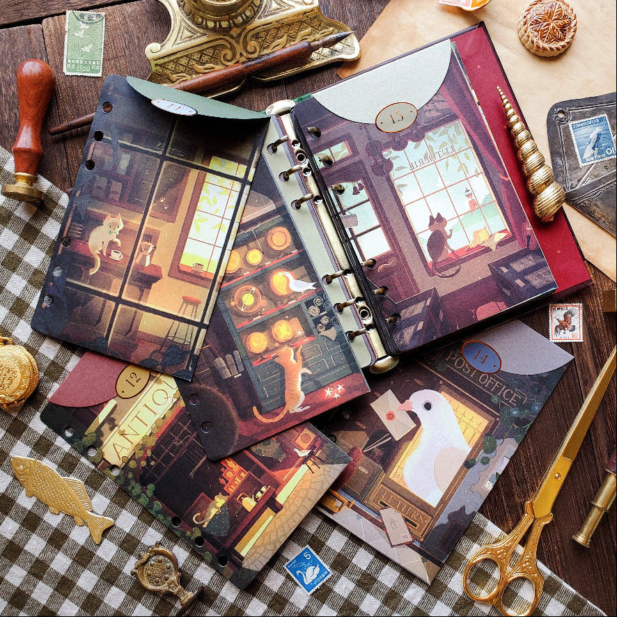 Decorative notebooks with illustrated covers on a checkered tablecloth with vintage items.