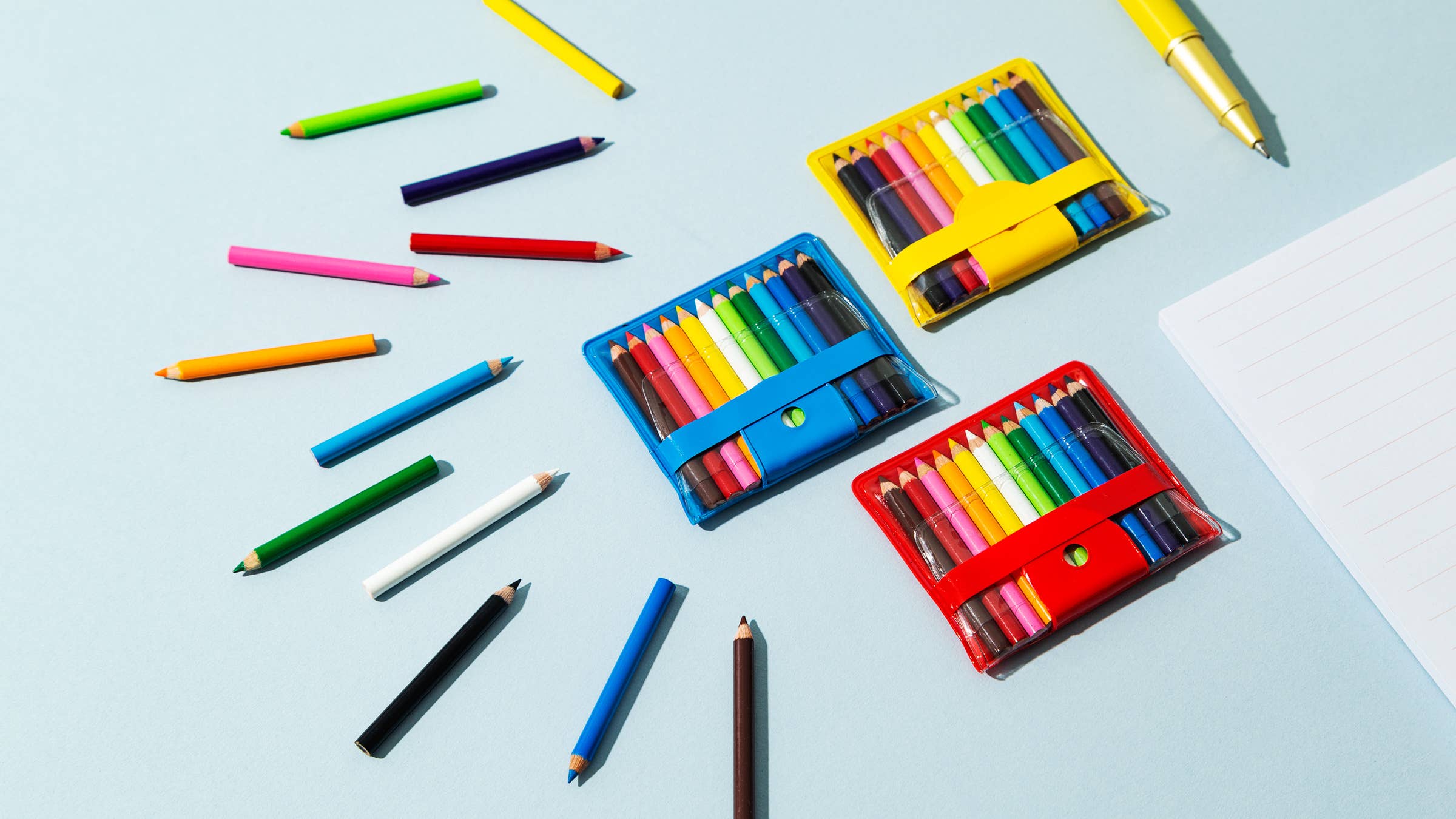 Colorful pencils and sets on a light blue background
