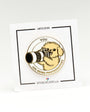 A circular enamel pin featuring a small dog holding a camera, with the text 'YOU ARE BEING PHOTOGRAPHED' around it, mounted on a white display card. The card has black border lines and text reading 'LIMITED EDITION' and 'OFFICIALEXCLUSIVE.