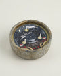 Candle with decorative label on a light gray background