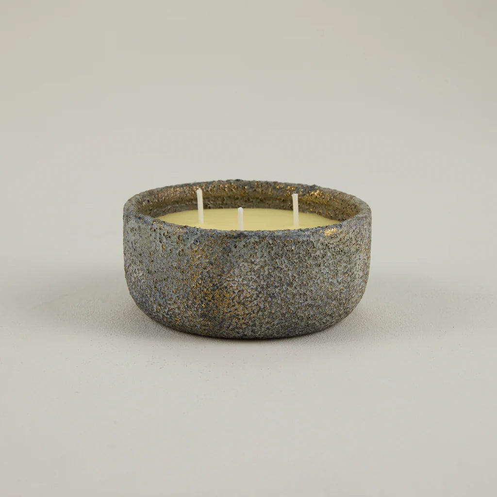 Ceramic bowl with a candle on a light gray background