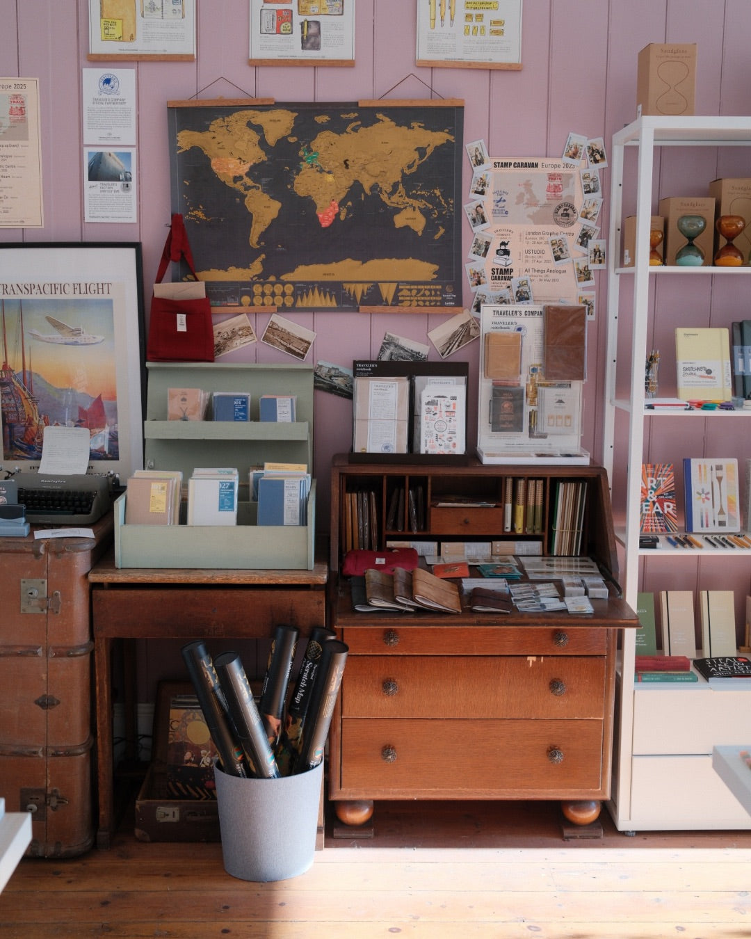 Room interior with wooden desk, world map, and shelves filled with books and decor.
