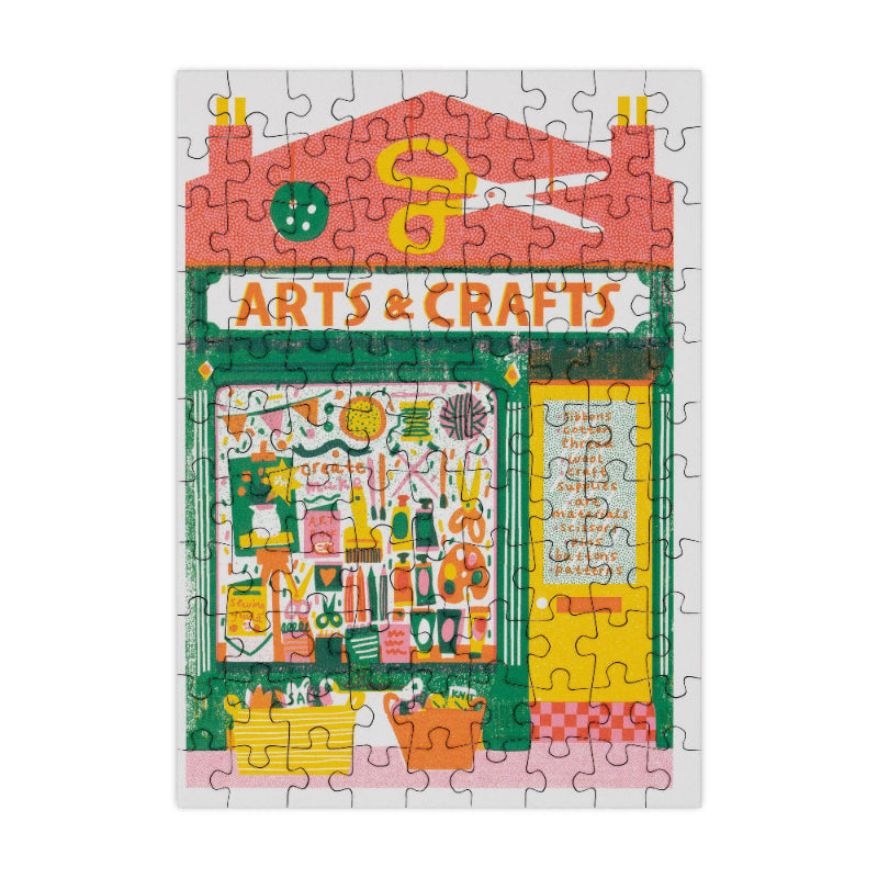 Jigsaw puzzle with a colorful design of an 'Arts & Crafts' store front.