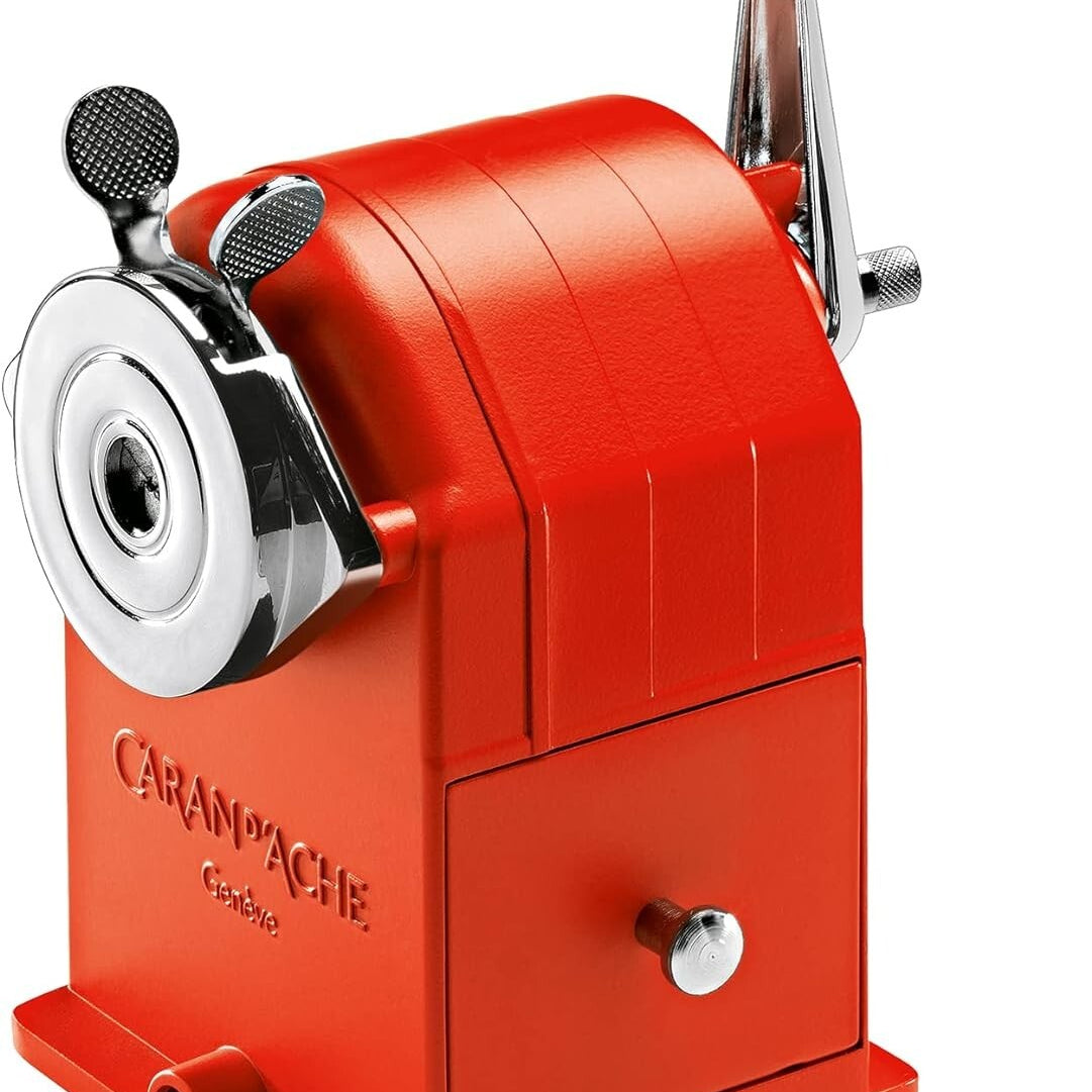 Red manual pencil sharpener with 'Caran d'Ache' branding on a white background