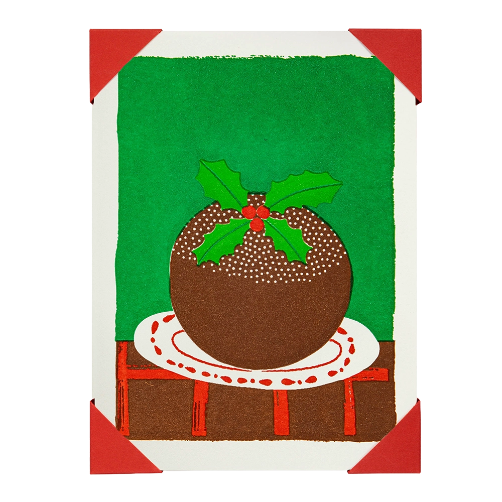 Christmas card with a brown pudding on a white plate against a green background