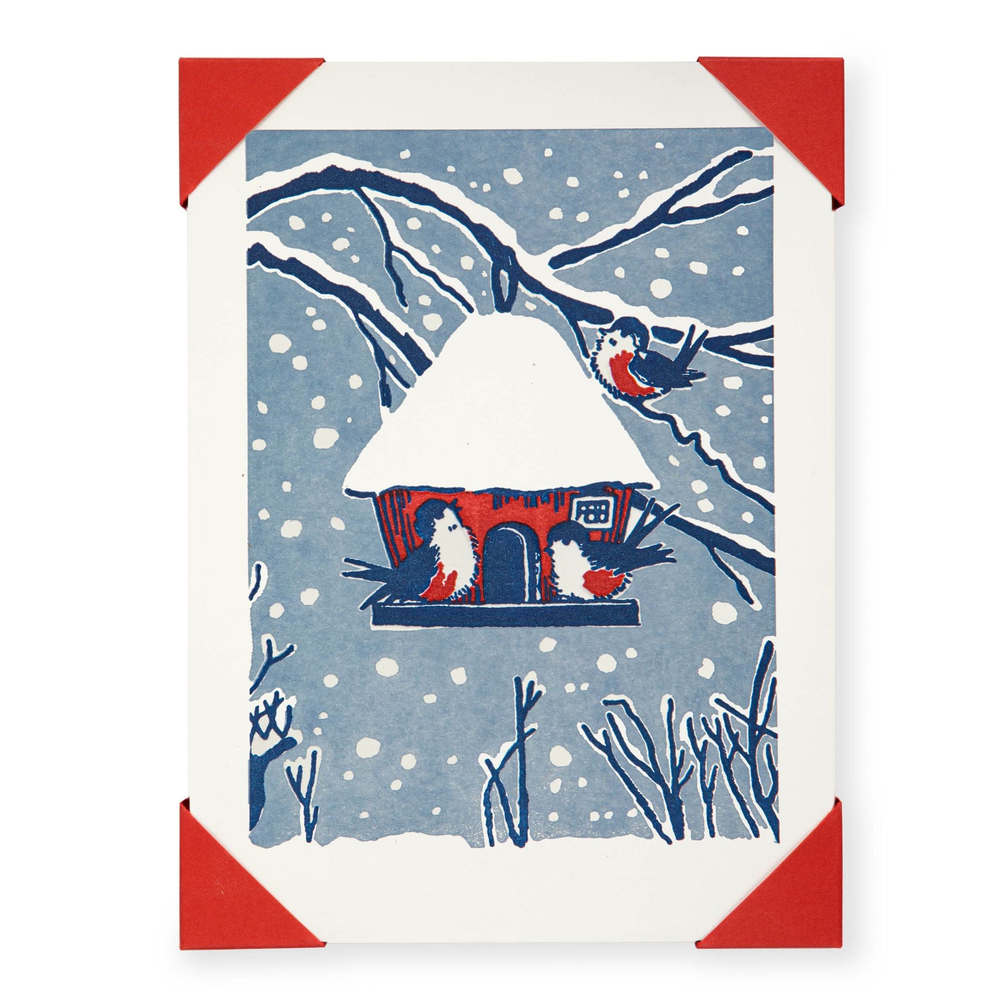 Card with a snowy scene featuring a birdhouse and birds, framed with red corners.