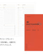 Daily planner with red cover and grid layout on white background