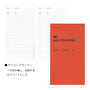 Daily planner with red cover and grid layout on white background