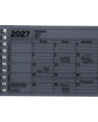 A 2027 spiral-bound notebook calendar on a plain white background. The cover is a muted gray-blue color with black printed text and grid lines, and the dates have been handwritten in black ink.