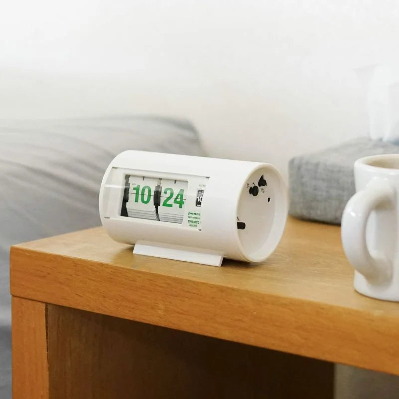 Flip clock on a wooden surface with a mug in the background
