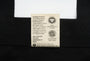 Label on a black garment with text about organic cotton and fair trade practices.