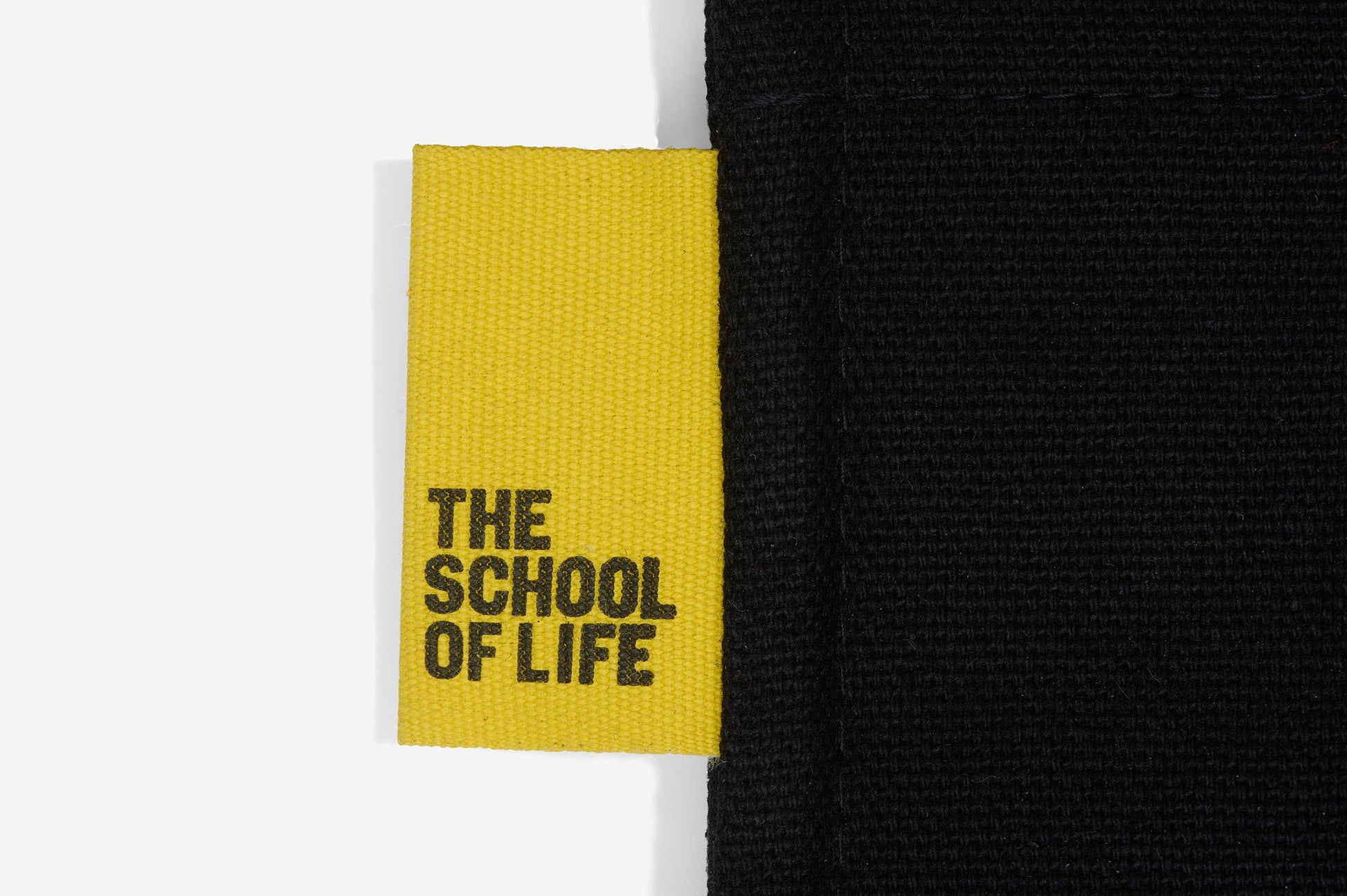Yellow label with 'The School of Life' text on a black background