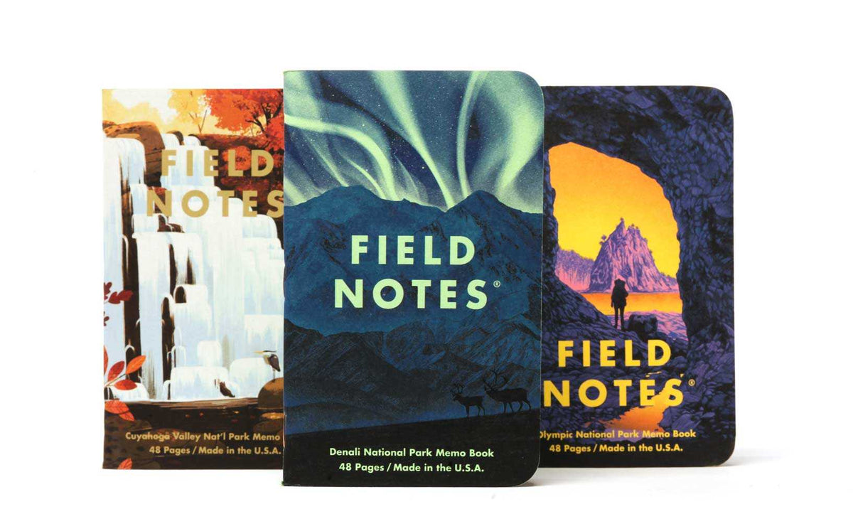 Three Field Notes notebooks with different national park designs on a white background