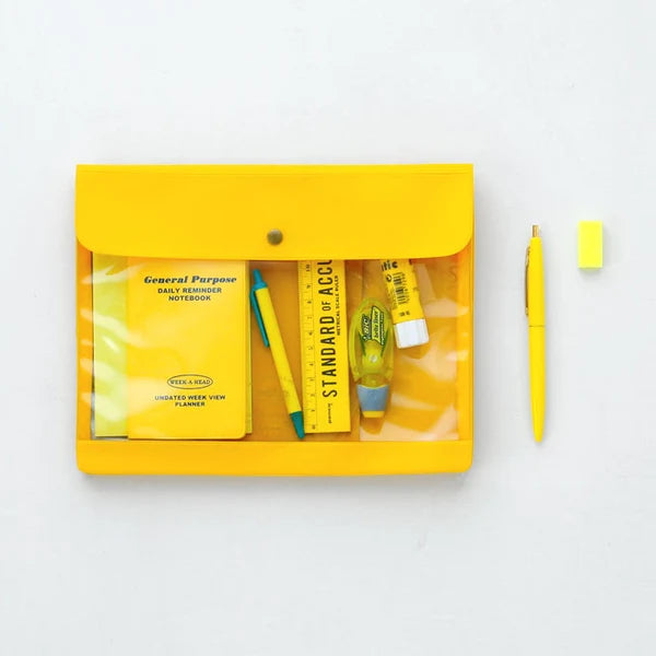 A yellow translucent plastic organizer pouch with a snap closure, shown open on a white background. Inside are several yellow and blue school or office accessories, including a notebook, pen, ruler, highlighter, and small tube.