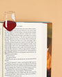 Open book with a wine glass bookmark on a beige background