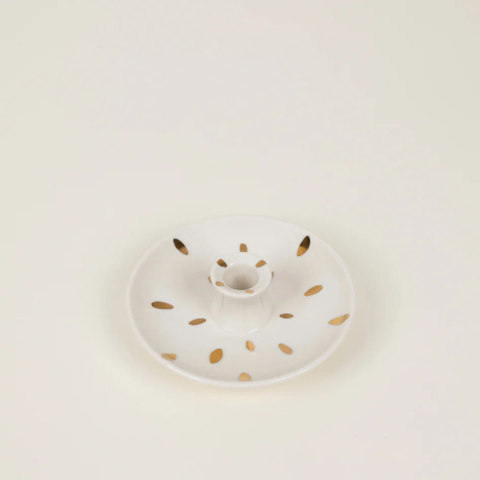 White ceramic plate with gold speckles on a light beige background