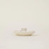 White ceramic dish with a small cup on a light beige background