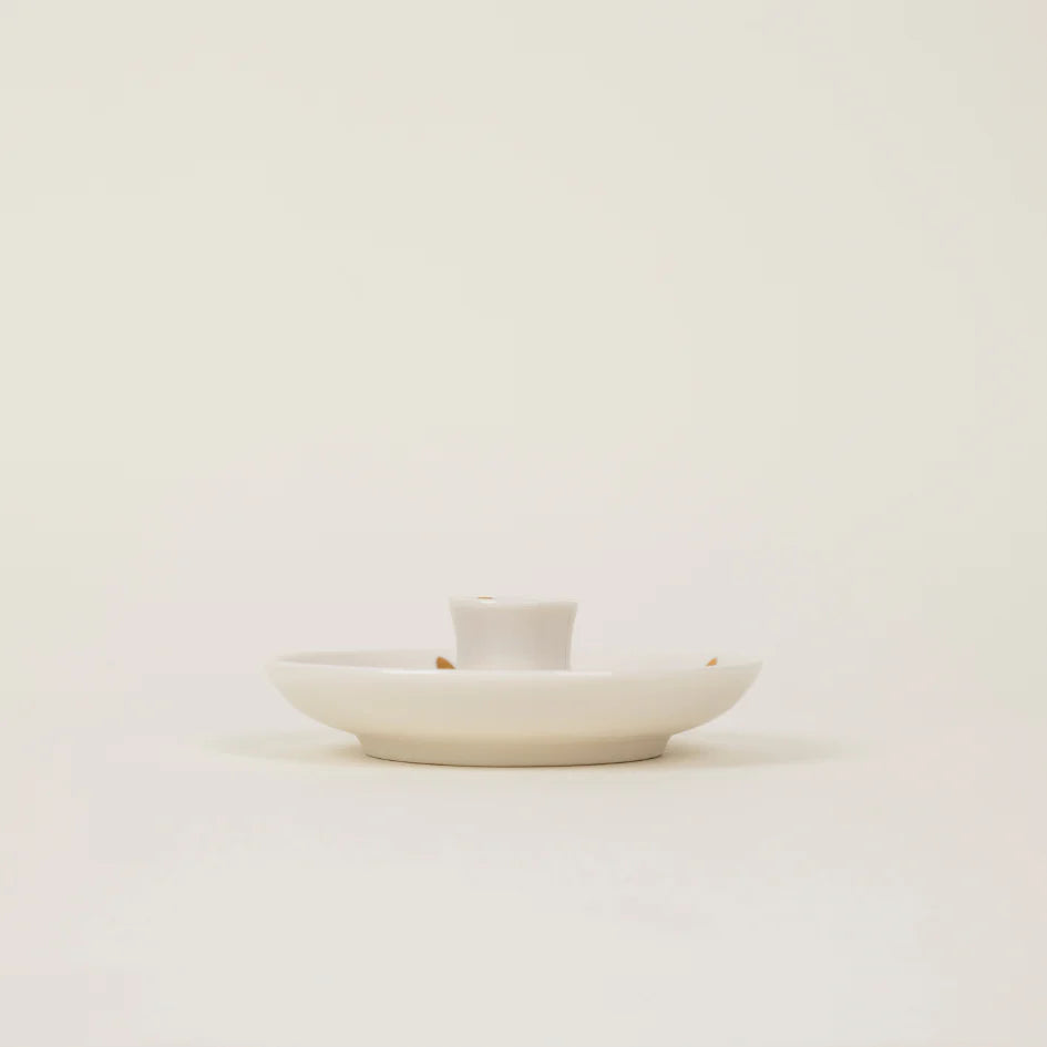 White ceramic dish with a small cup on a light beige background