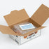 Open cardboard box with bakery branding, containing ice packs and an invoice on a white background