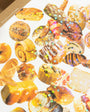 Assorted pastries on a white surface with a cardboard box in the background