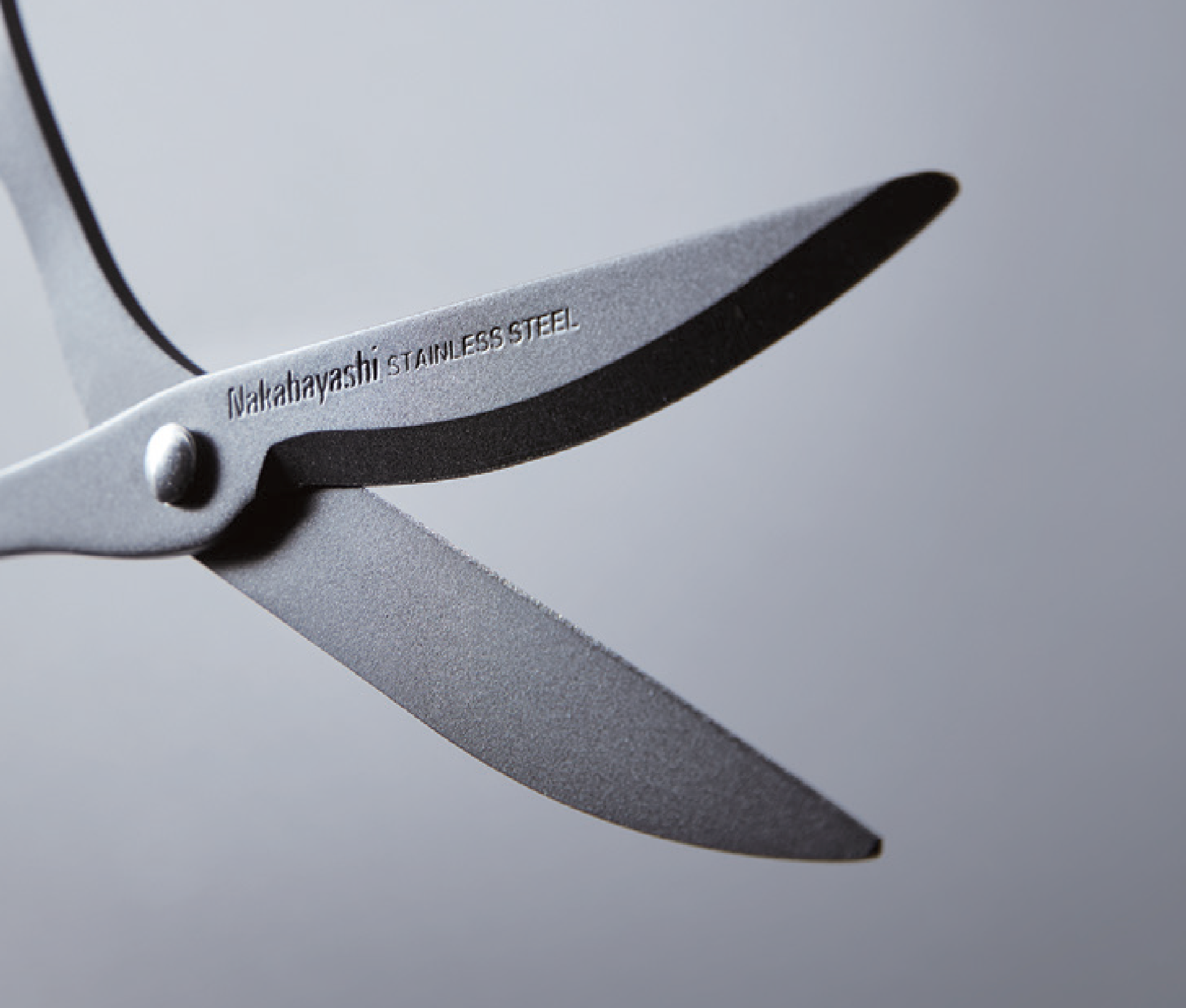Close-up of a pair of scissors with Nakabayashi Stainless Steel branding on a gray background