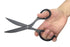 Hand holding a pair of black scissors against a white background