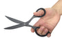 Hand holding a pair of black scissors against a white background