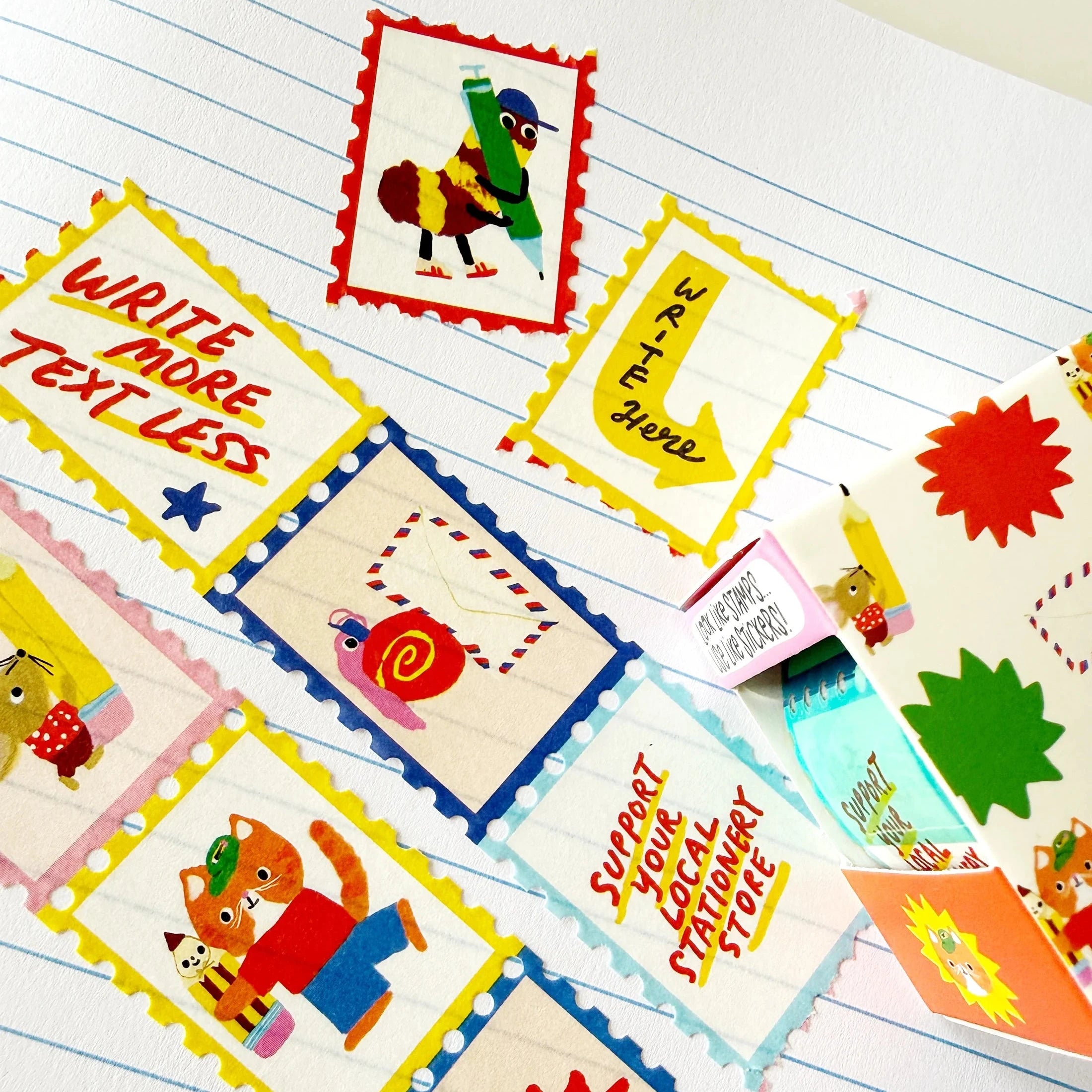A close-up of colorful educational bookmarks or bookmark cards laid out on lined paper. The cards have scalloped edges and cartoon illustrations, including a red stamp-like card reading 'WRITE MORE TEXT LESS,' a yellow arrow card reading 'TRY MORE,' a blue border card with a snail, a fox, and a starburst card reading 'TODAY ONLY!'.