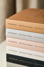Close up of staked Katie Leamon notebooks