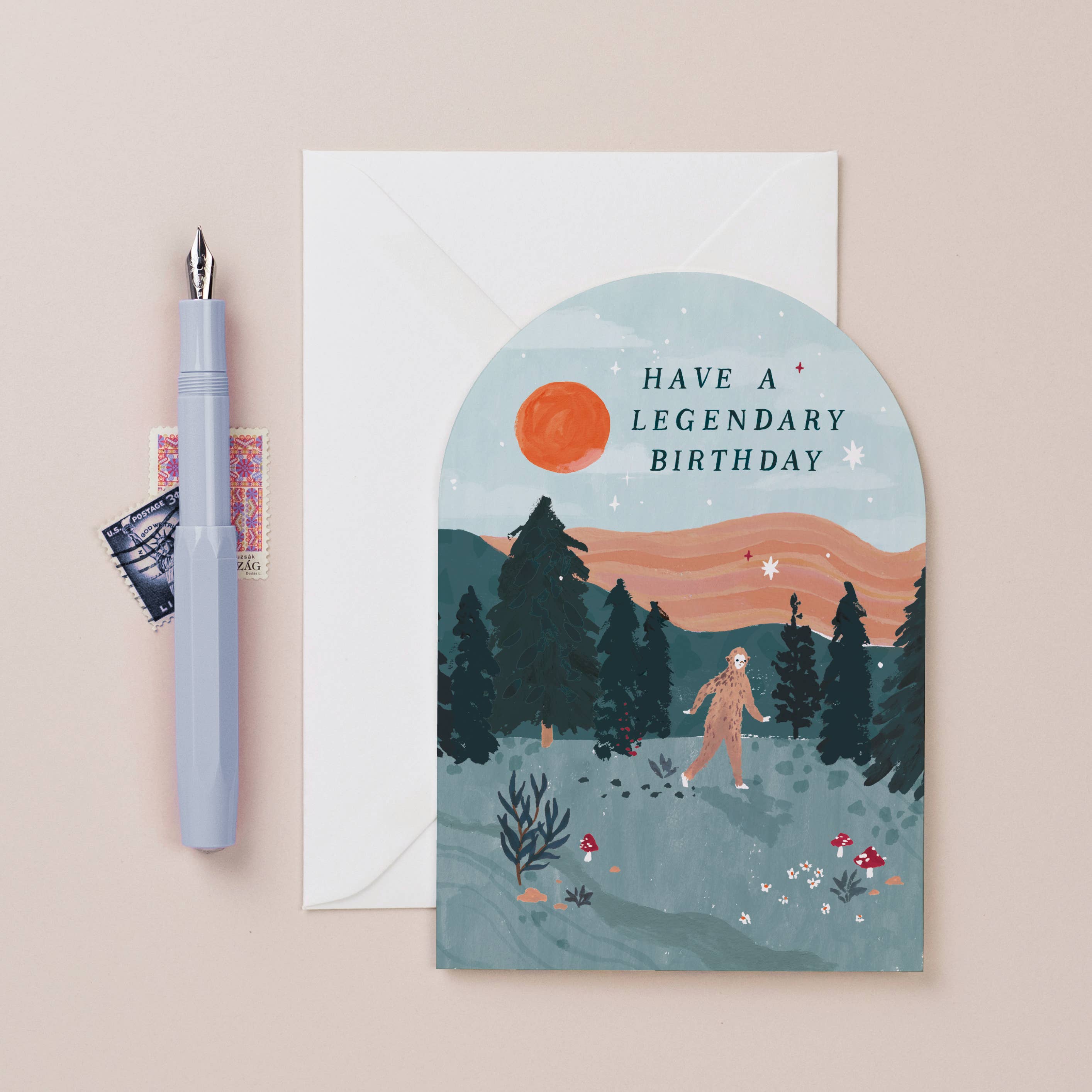 Greeting card with 'Have a Legendary Birthday' text, pen, and envelope on a beige background