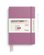 A Leuchtturm1917 2027 weekly planner in a dusty purple/magenta color, shown with its white paper band and a white pen on a clean white background.