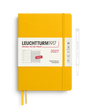 A Leuchtturm1917 2027 weekly planner notebook in a bright yellow hardcover, shown with a white paper band around the middle and a matching yellow ribbon bookmark. A thin pen outline is visible to the right on a clean white background.