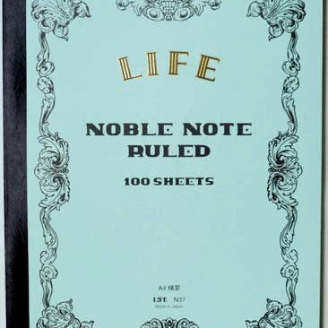 Notebook with decorative cover and 'Noble Note' text on a light blue background