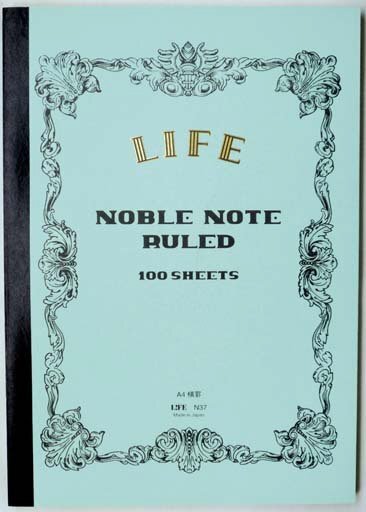 Notebook with decorative cover and 'Noble Note' text on a light blue background
