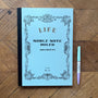 Blue notebook with decorative cover and a pen on a wooden surface