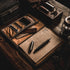 Brown leather travel set with stationery items on a wooden surface
