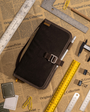 Brown leather portfolio with tools on a newspaper background