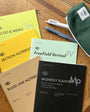 Collection of notebooks and a pen on a wooden surface