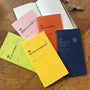 Collection of colorful planners and notebooks on a wooden surface