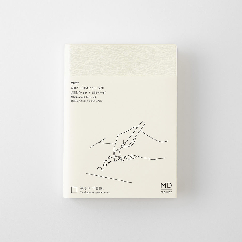 A cream-colored daily planner notebook with minimalist black line art and Japanese text, shown in its packaging against a light gray background.