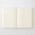 An open cream-colored planner or notebook with lined pages and bracket headers, photographed flat against a light gray background.