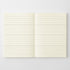 An open notebook with cream-colored lined pages, displayed flat against a light gray background.