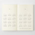 An open book or planner spread showing two cream-colored pages with printed calendar grids for 2027 and 2028, photographed against a light gray background.