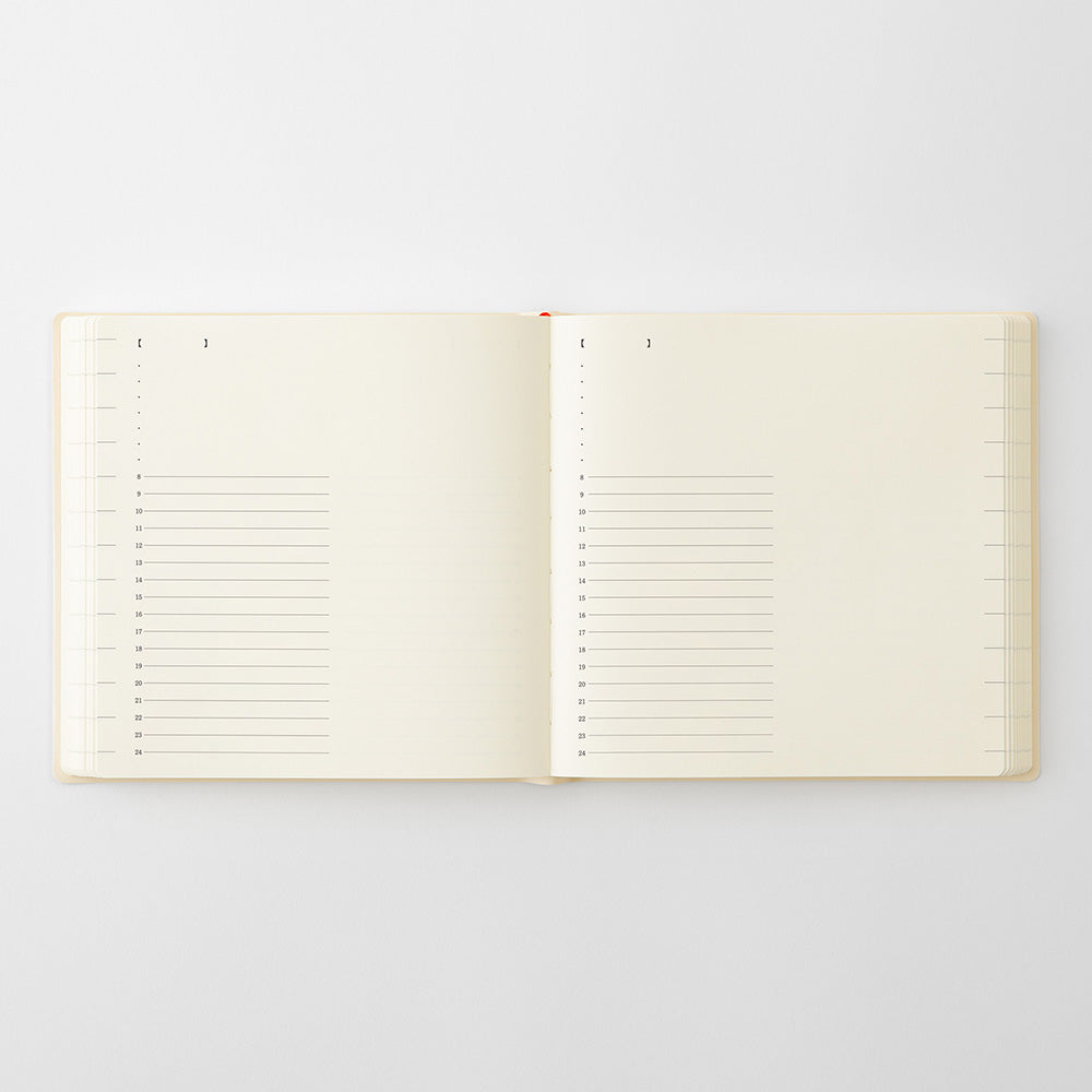 An open cream-colored notebook with lined pages, photographed flat against a light gray background.