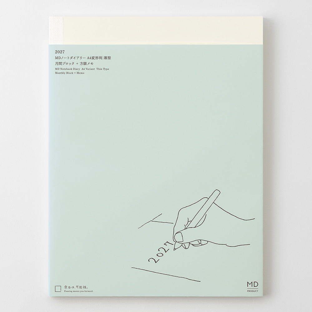 A mint green 2027 monthly art book or notebook with Japanese text at the top and a minimalist line drawing of a hand writing '2027' at the bottom right. The top cover has a cream-colored horizontal band, and the cover is photographed against a clean white background.