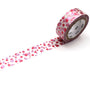 Roll of pink dotted patterned tape with a trail on a white background