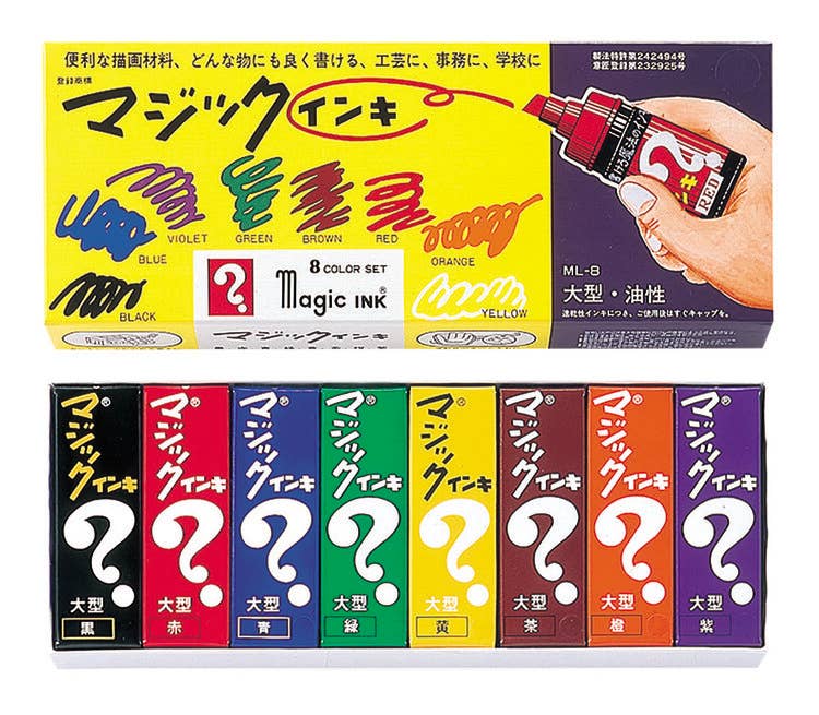 Box of Magic Ink with colorful packaging and a hand holding an ink bottle.