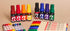 Set of colorful markers and pens on a beige background